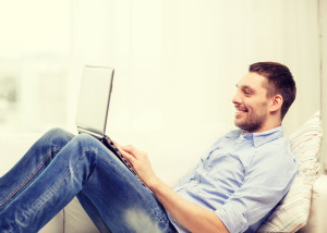 technology, home and lifestyle concept - smiling man working wit